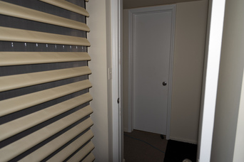 blinds, an open doorway, and a closed door