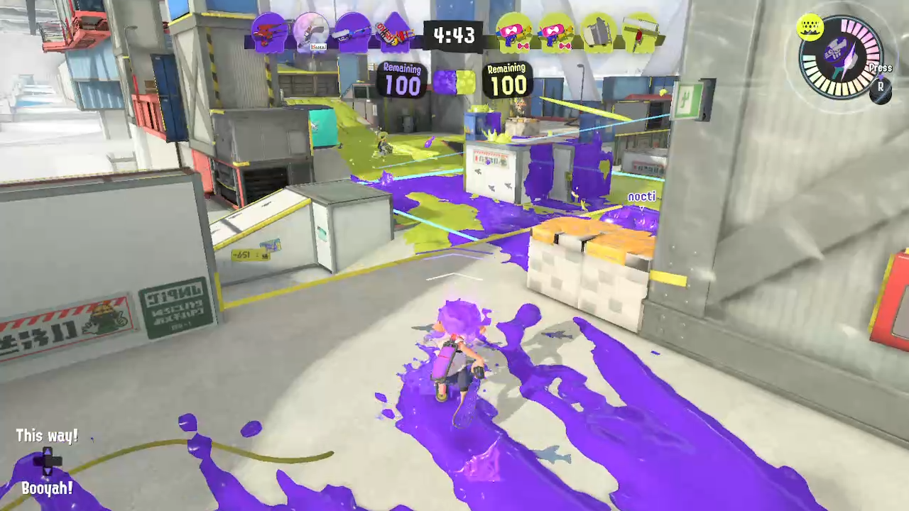 A purple octoling shoving a brush approaches the splat zone on Hammerhead Bridge. Several opponents are in mid with yellow ink, but the zone is evenly split with no scoring at 4m43s on the clock. The player has special ready.