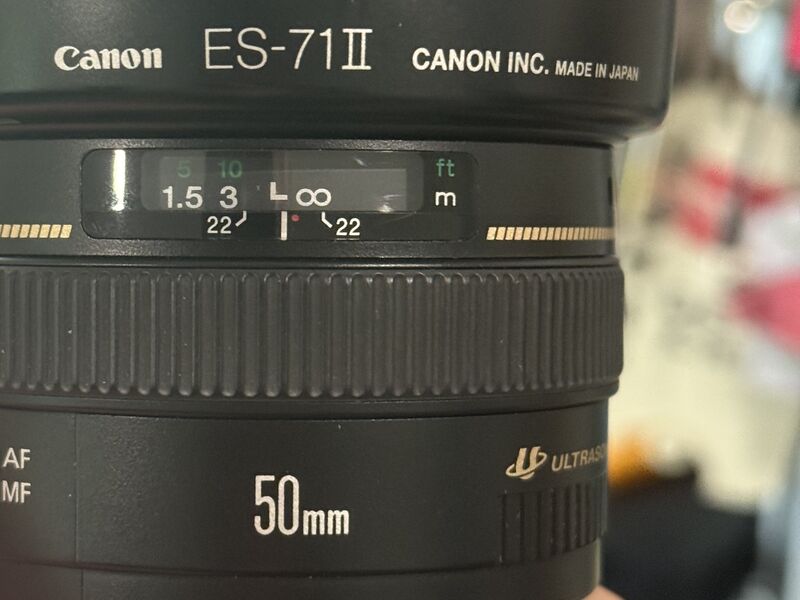 a little red dot next to the focus range indicator on a black 50mm lens