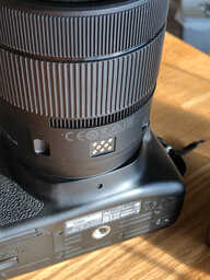 the bottom of a camera lens, with eight flat contacts and a ring of sprocket teeth